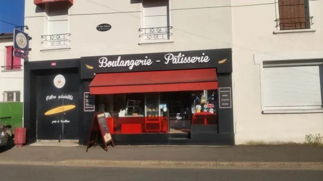 La façade de la boulangerie, enseigne Boulangerie - Pâtisserie et store rouge