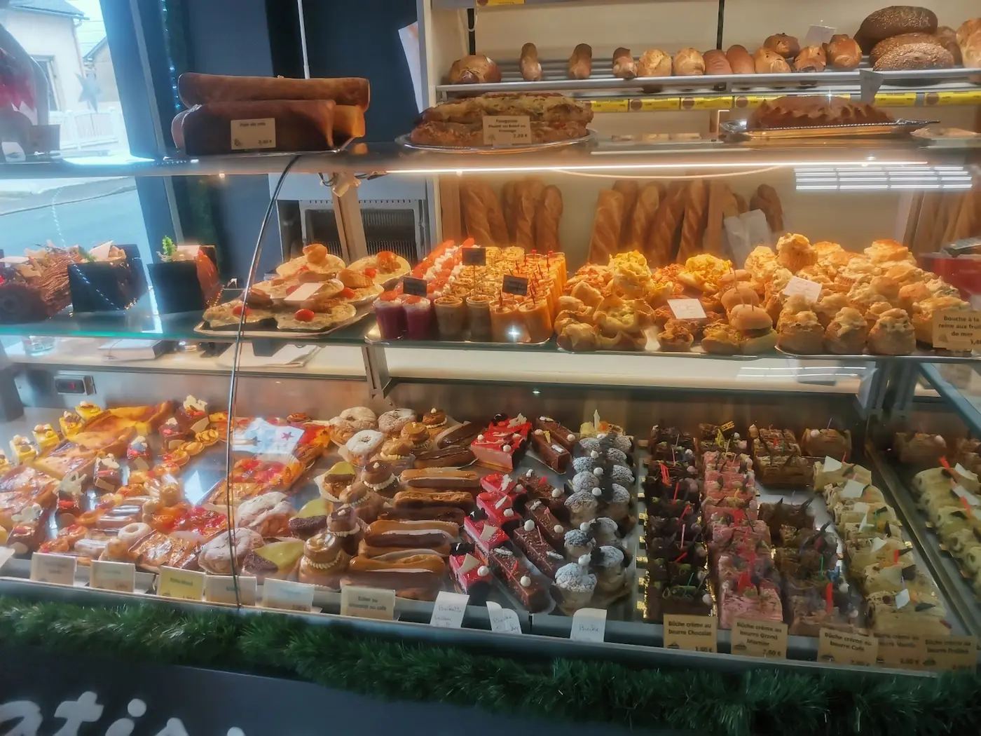 La vitrine de la boulangerie : pains et viennoiseries en haut, pâtisseries en dessous